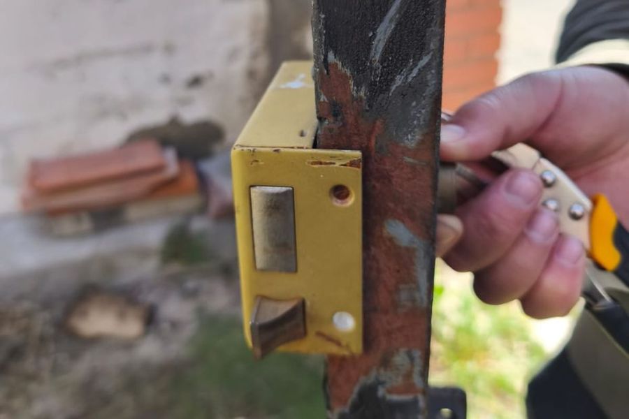Cerrajero reparando y cambiando una cerradura desgastada